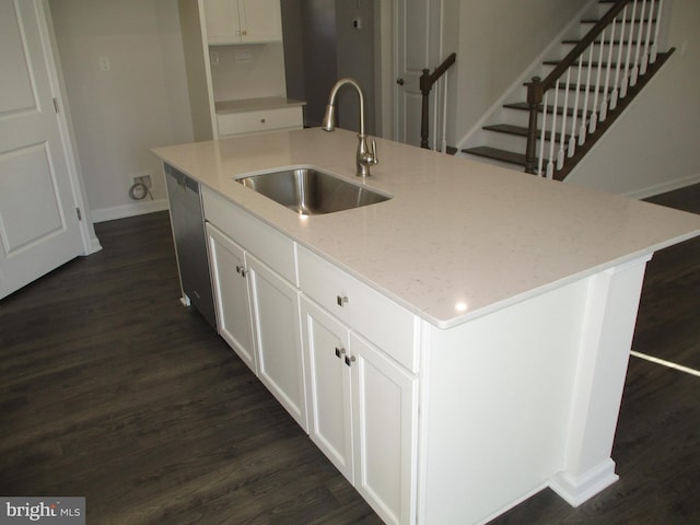 kitchen featuring a center island with sink, white cabinetry, light stone countertops, and sink