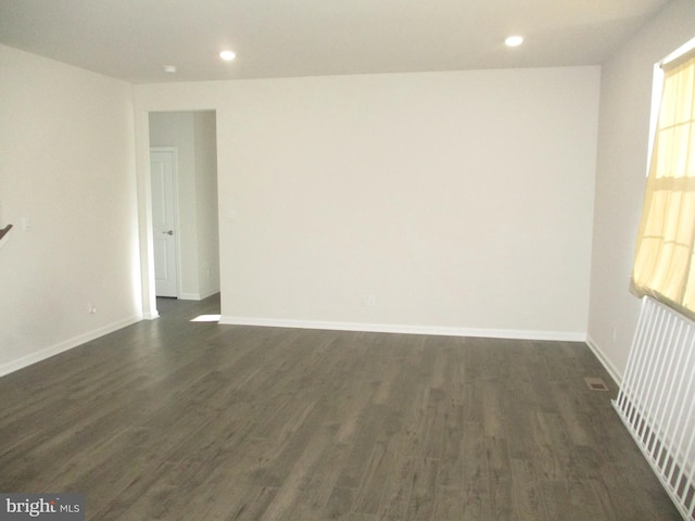 unfurnished room featuring radiator and dark hardwood / wood-style flooring