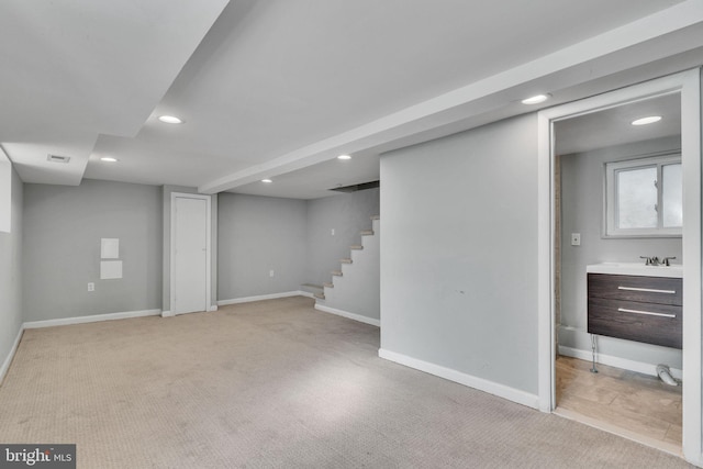 basement with light colored carpet and sink