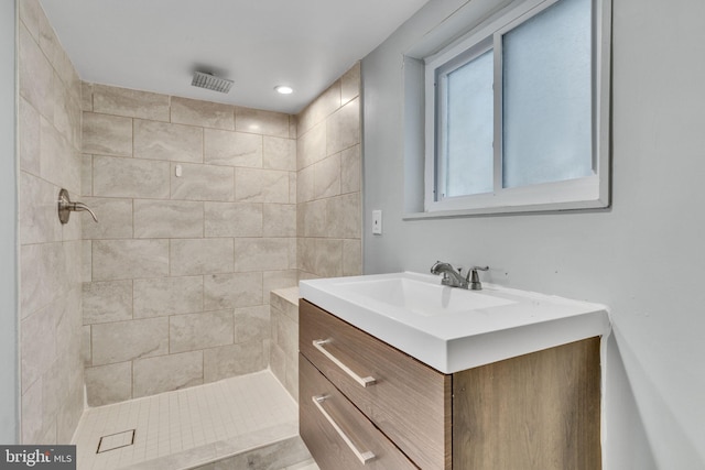 bathroom with vanity and tiled shower