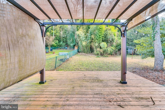 wooden terrace featuring a pergola and a lawn