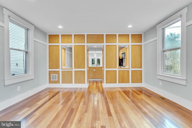 unfurnished room featuring a baseboard heating unit and hardwood / wood-style floors