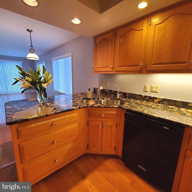 kitchen featuring sink, pendant lighting, light hardwood / wood-style flooring, dark stone countertops, and dishwasher