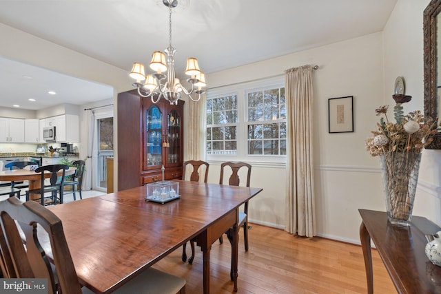 dining space featuring light hardwood / wood-style flooring and a notable chandelier