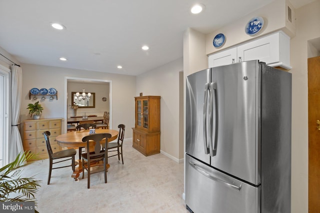 kitchen featuring white cabinets, a notable chandelier, and stainless steel fridge