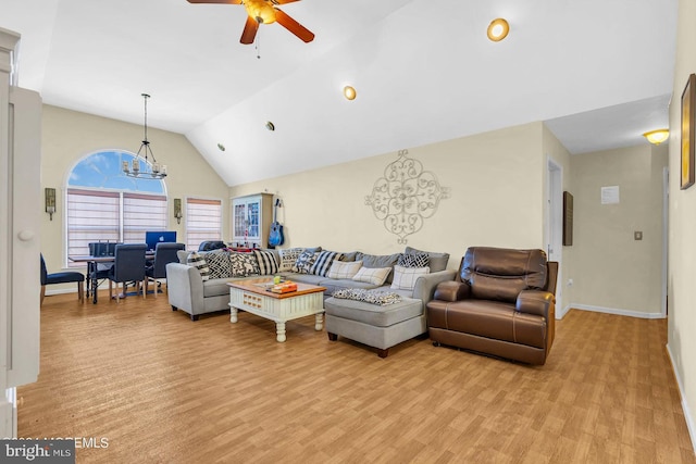 living room with vaulted ceiling, light hardwood / wood-style flooring, and ceiling fan with notable chandelier