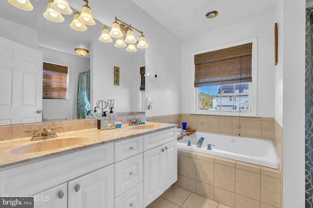 bathroom featuring tile patterned floors, vanity, and tiled tub