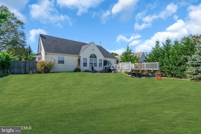 rear view of house with a yard and a wooden deck