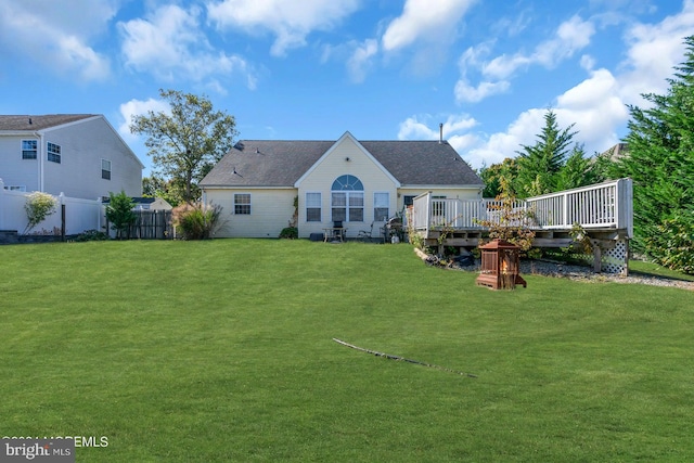 rear view of property featuring a lawn and a wooden deck