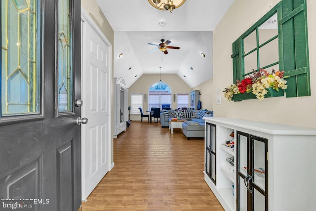 foyer entrance with hardwood / wood-style flooring, ceiling fan, and vaulted ceiling