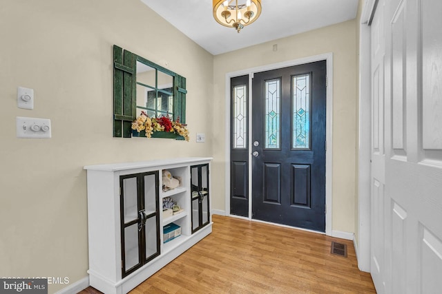 entrance foyer with light hardwood / wood-style flooring and an inviting chandelier