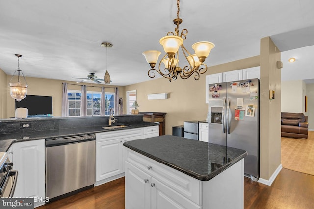 kitchen with ceiling fan with notable chandelier, white cabinetry, stainless steel appliances, and decorative light fixtures