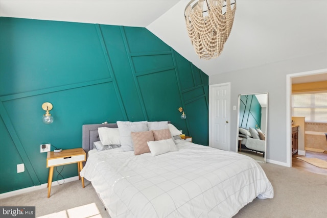 carpeted bedroom with vaulted ceiling and ensuite bathroom