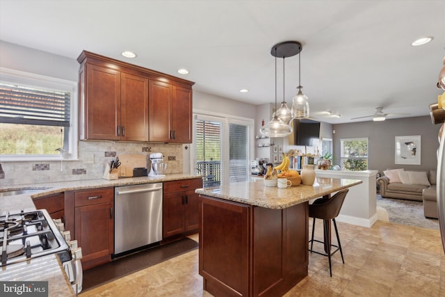 kitchen with white gas range, sink, decorative light fixtures, dishwasher, and plenty of natural light