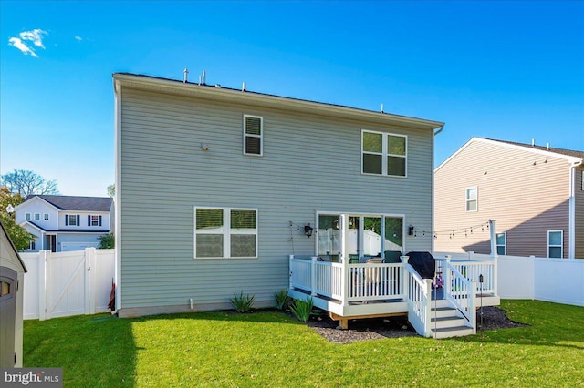 rear view of house with a lawn and a wooden deck