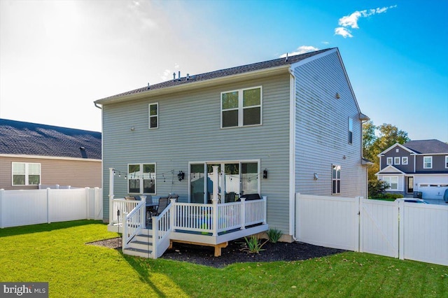 rear view of house with a deck and a yard