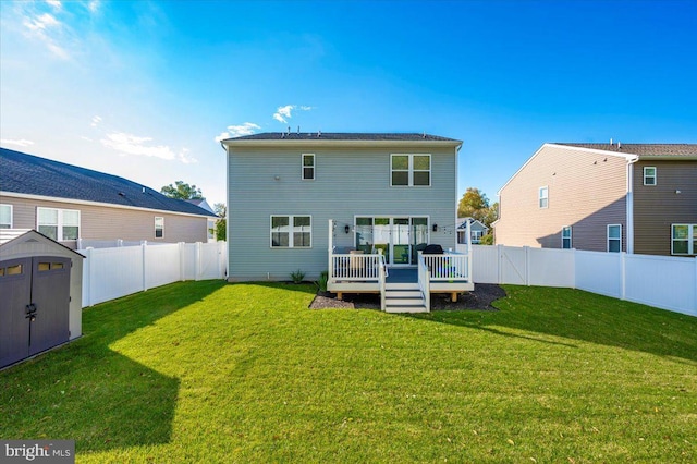 rear view of house featuring a shed, a yard, and a wooden deck