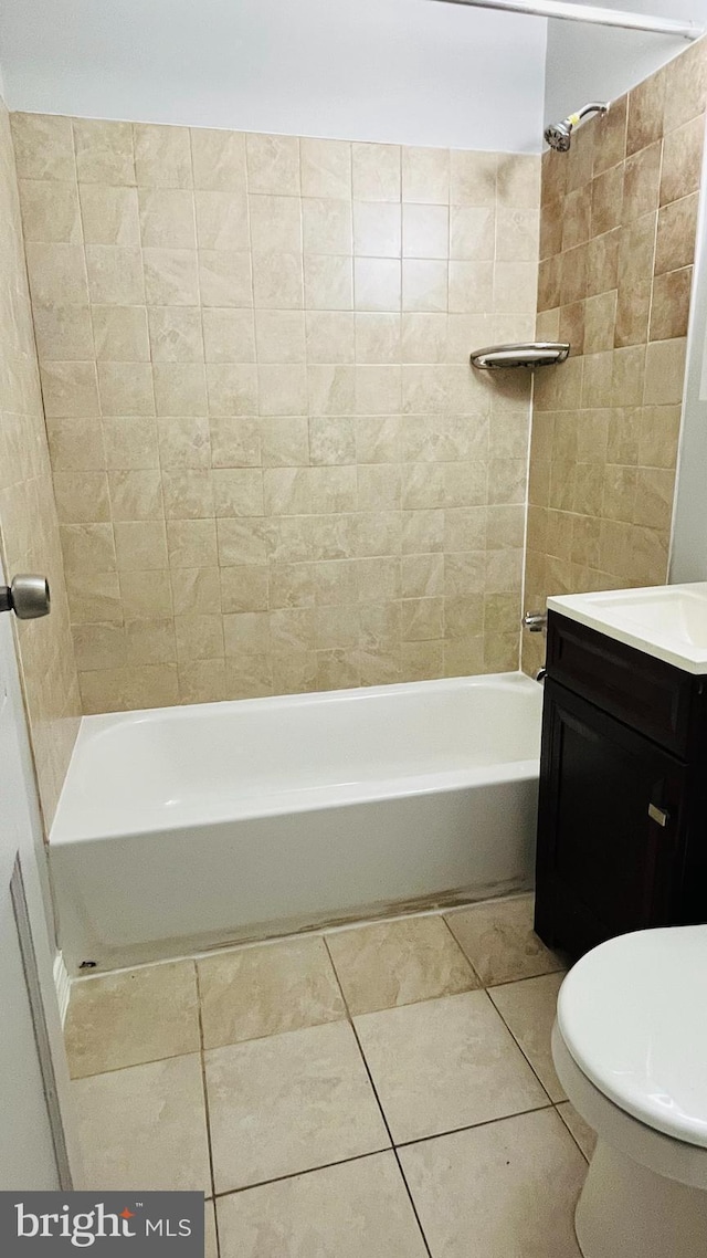 full bathroom featuring tile patterned flooring, vanity, toilet, and tiled shower / bath combo