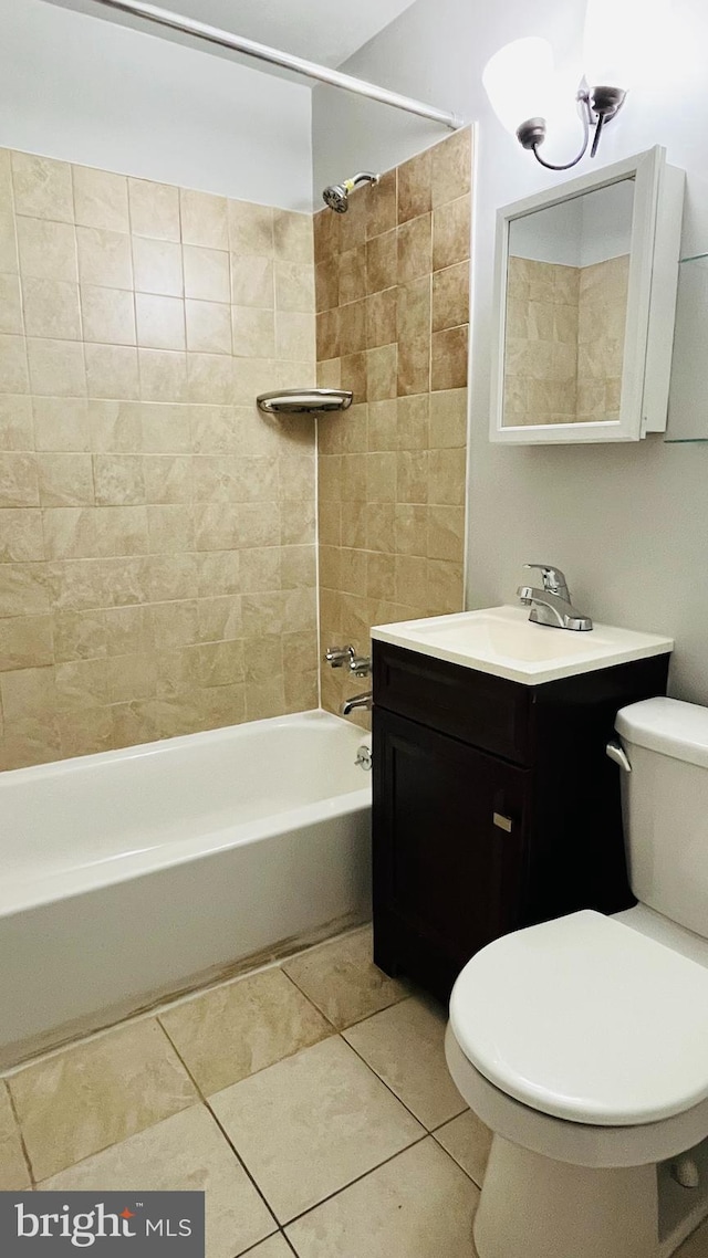 full bathroom featuring tile patterned floors, vanity, tiled shower / bath combo, and toilet