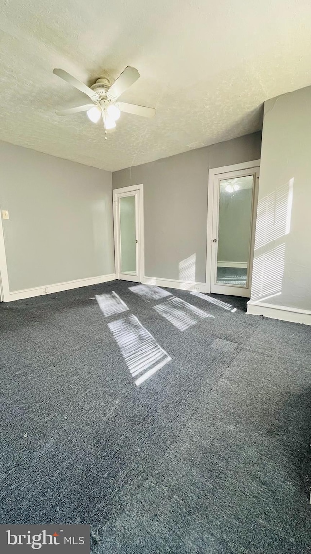 spare room with carpet flooring, ceiling fan, and a textured ceiling