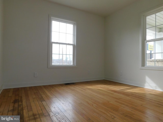 empty room with plenty of natural light and light wood-type flooring