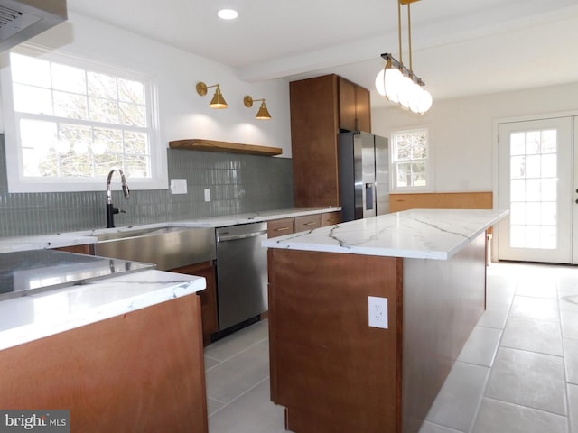 kitchen featuring sink, a center island, pendant lighting, stainless steel appliances, and backsplash