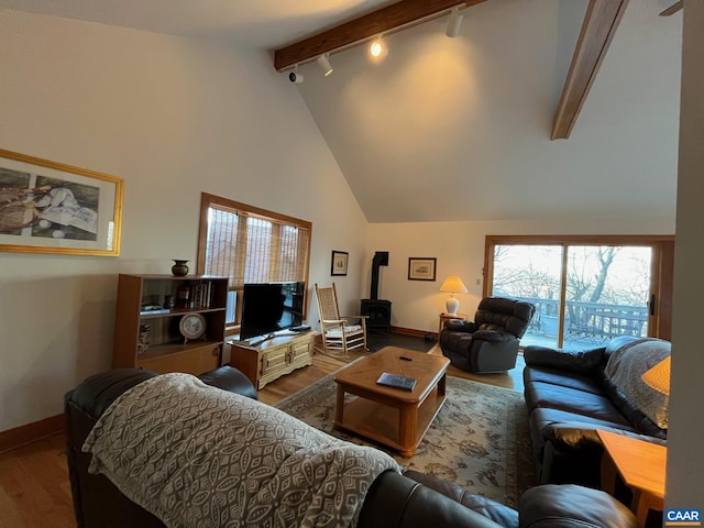 living room with track lighting, wood-type flooring, high vaulted ceiling, beamed ceiling, and a wood stove