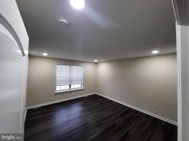 empty room with dark hardwood / wood-style flooring