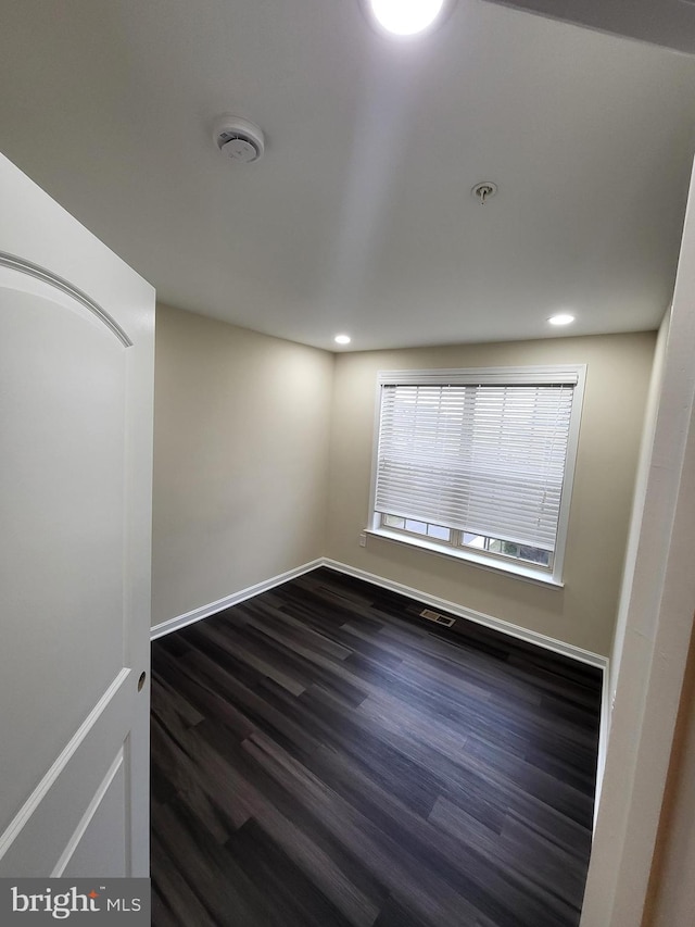 empty room with dark wood-type flooring