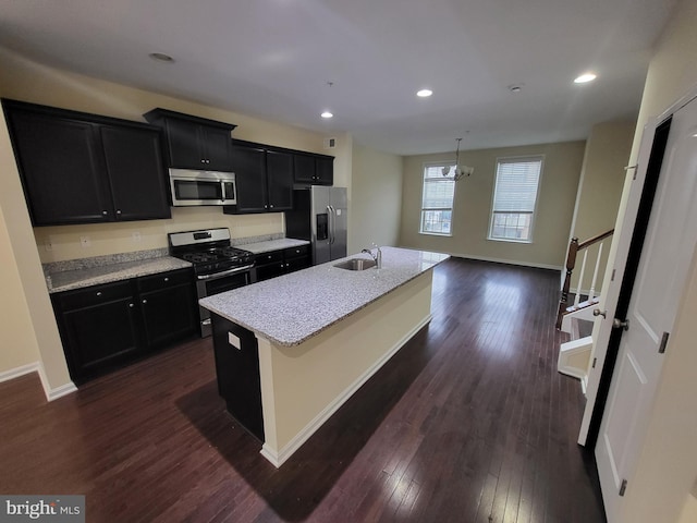 kitchen with a kitchen island with sink, sink, a notable chandelier, dark hardwood / wood-style flooring, and stainless steel appliances