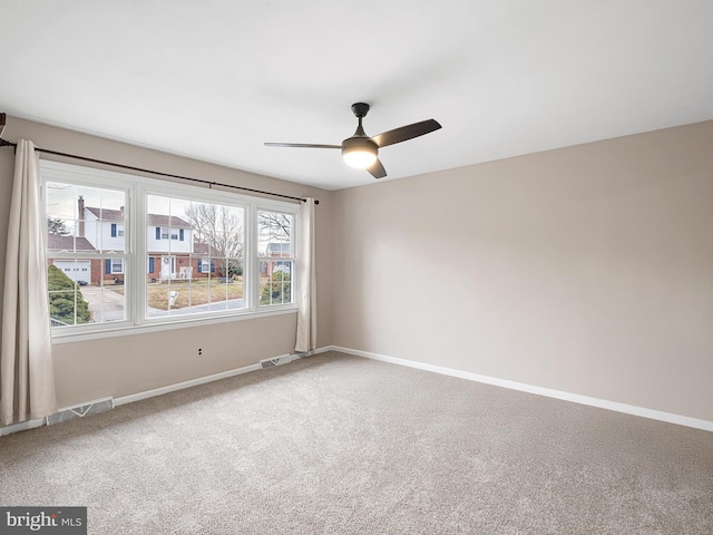 carpeted spare room with a wealth of natural light and ceiling fan