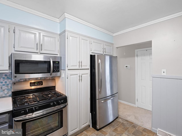 kitchen featuring backsplash, light carpet, crown molding, white cabinetry, and stainless steel appliances