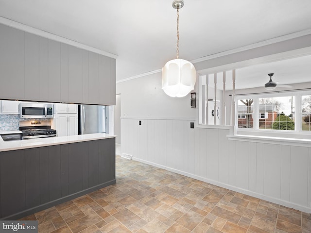 kitchen featuring white cabinetry, ceiling fan, hanging light fixtures, stainless steel appliances, and crown molding