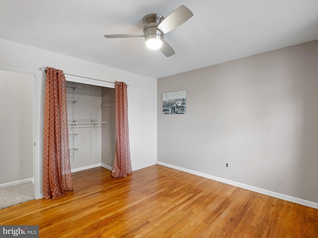 unfurnished bedroom with hardwood / wood-style floors, ceiling fan, and a closet