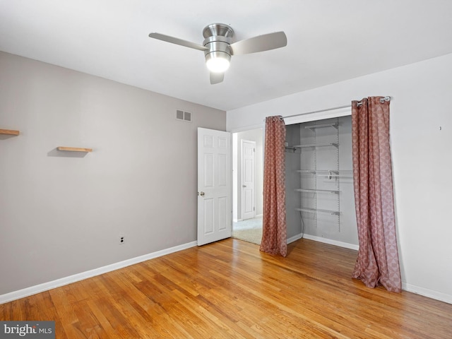 unfurnished bedroom with wood-type flooring, a closet, and ceiling fan