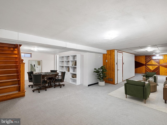 interior space with carpet flooring, a wealth of natural light, and wooden walls