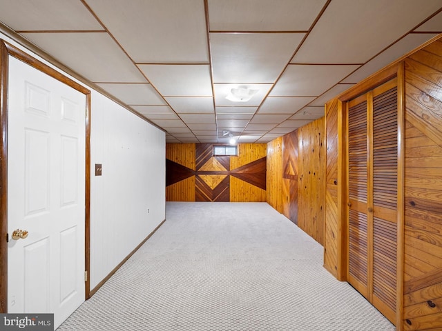 basement with carpet flooring and wooden walls