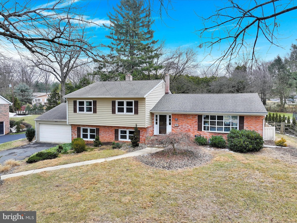 tri-level home with a garage and a front yard