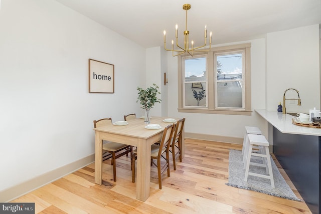 dining room featuring sink, light hardwood / wood-style floors, and an inviting chandelier