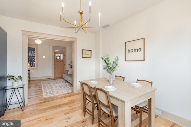 dining space with a chandelier and light hardwood / wood-style flooring