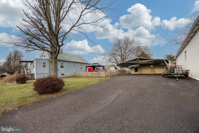 view of side of property featuring a lawn and a carport