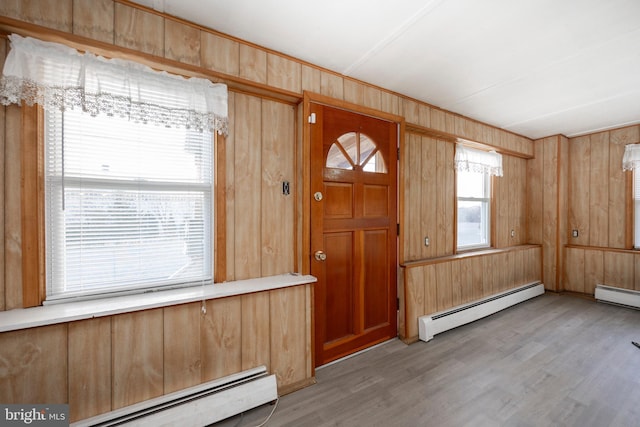 foyer featuring wood walls, a baseboard radiator, and light wood-style flooring