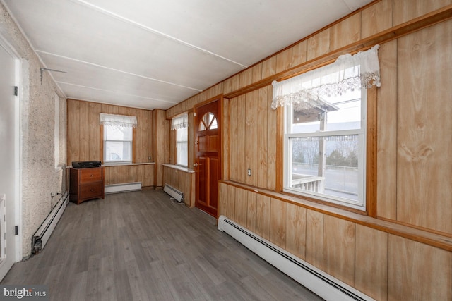 unfurnished room featuring a baseboard radiator, a healthy amount of sunlight, and a baseboard heating unit