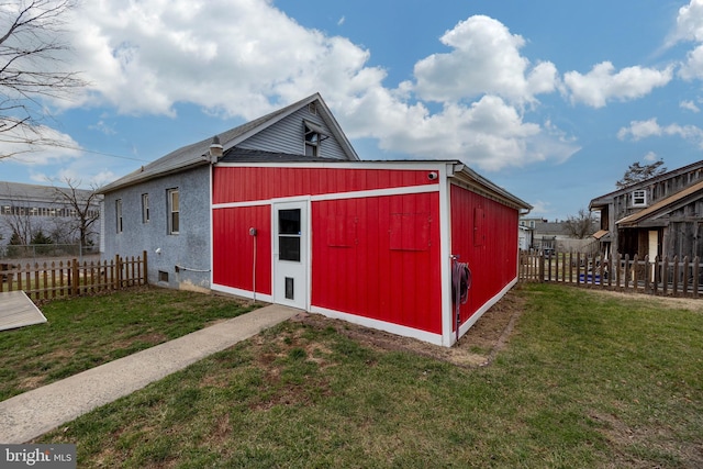 view of pole building with a lawn and fence