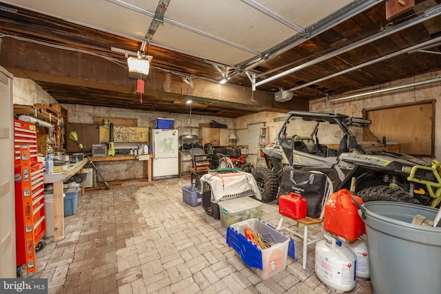 garage featuring a garage door opener and freestanding refrigerator