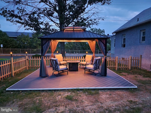 deck featuring a gazebo, an outdoor fire pit, and a fenced backyard