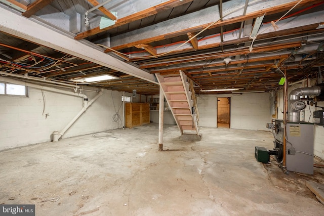 basement with a heating unit and concrete block wall