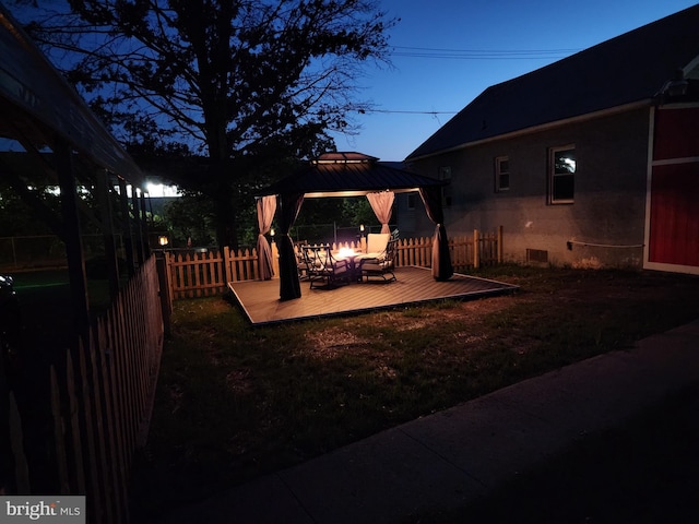 view of yard with a gazebo, an outdoor fire pit, a deck, and fence