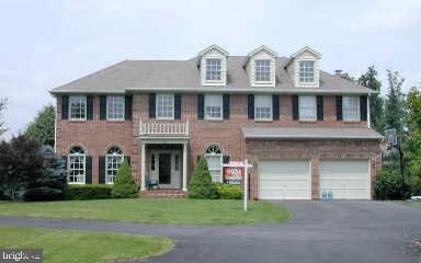 colonial-style house with a garage and a front lawn