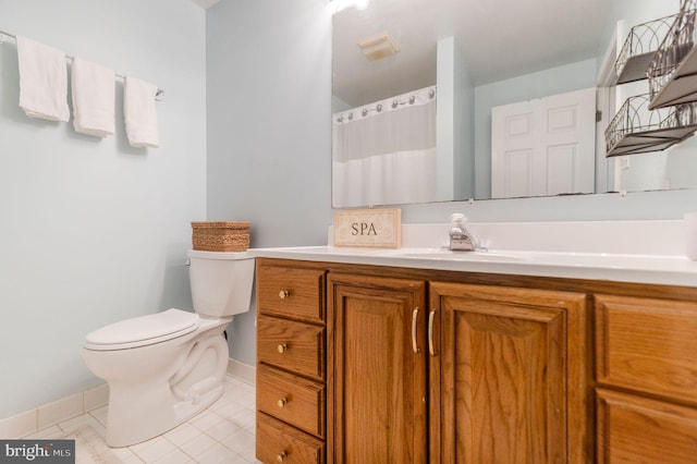 bathroom with vanity, toilet, and tile patterned flooring